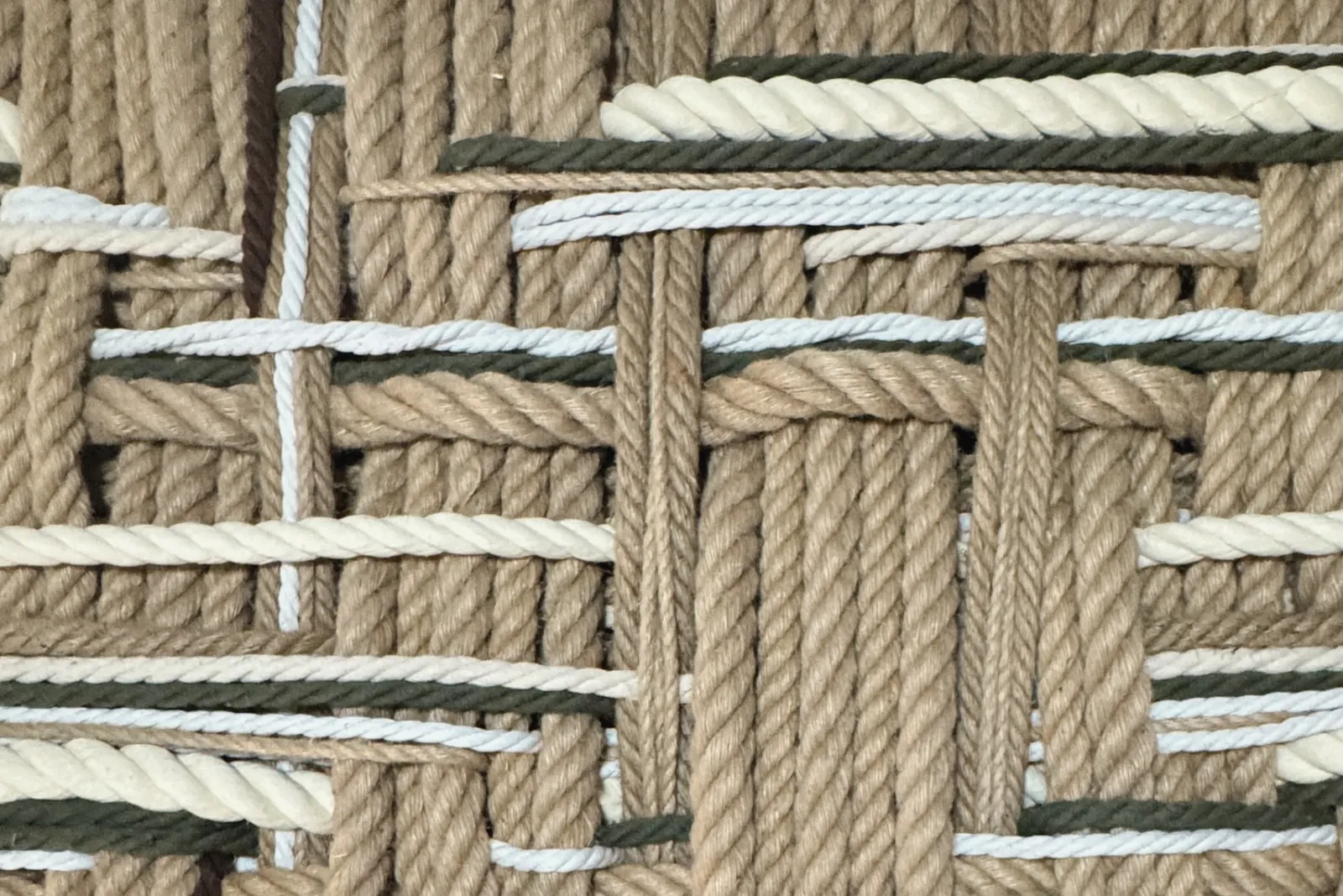 Detail of Iguén de Guaraguao: a woven grid of natural, green, and white rope